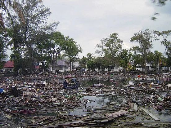 Trash and debris cover the streets near homes in Banda Aceh, Indonesia, following the 2004 tsunami. Source: