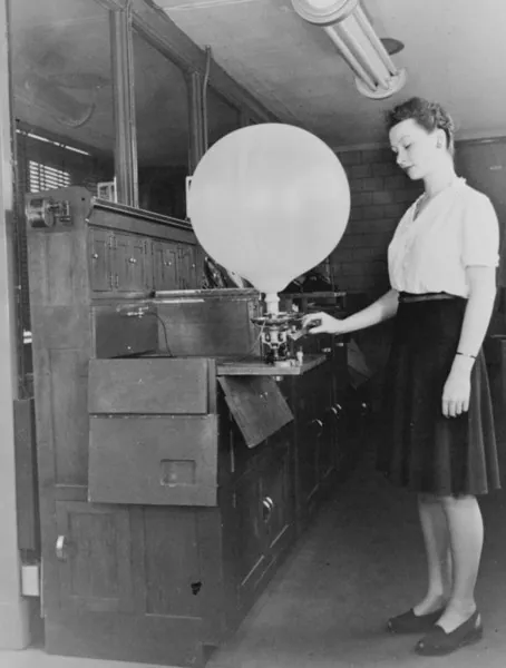 Inflation of a pilot balloon used to determine cloud heights as well as wind speed and direction as the balloon ascended.
